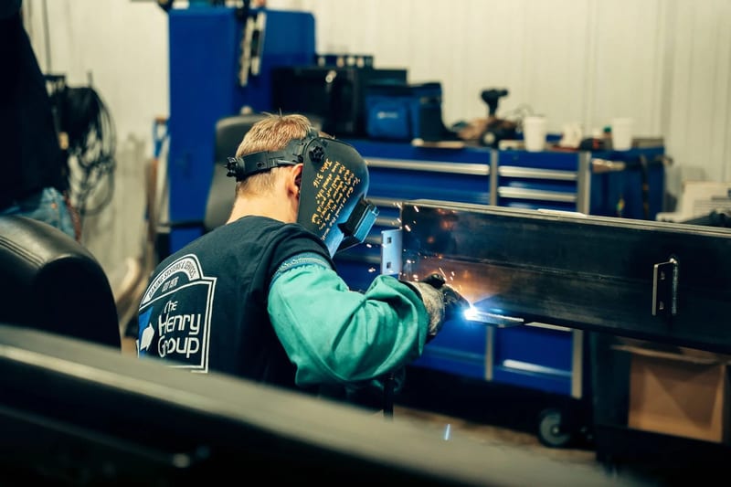 THG welder working on a metal part at a fabrication bench