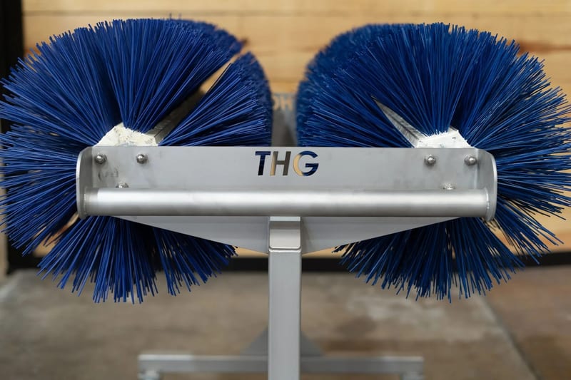 Blue cylindrical brushes mounted on a THG brush cart