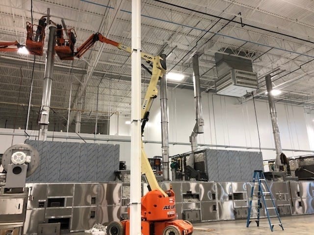 Lifting equipment and crew installing overhead exhaust ducting