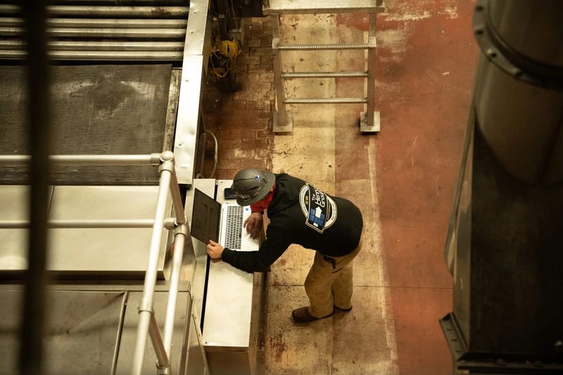 THG technician beside an access ladder during field work