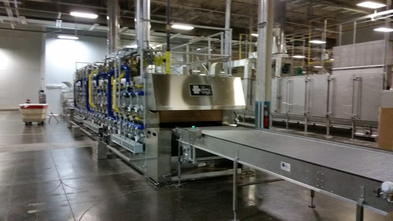Burner side of the meter-wide hearth-plate tunnel oven, with its discharge conveyor