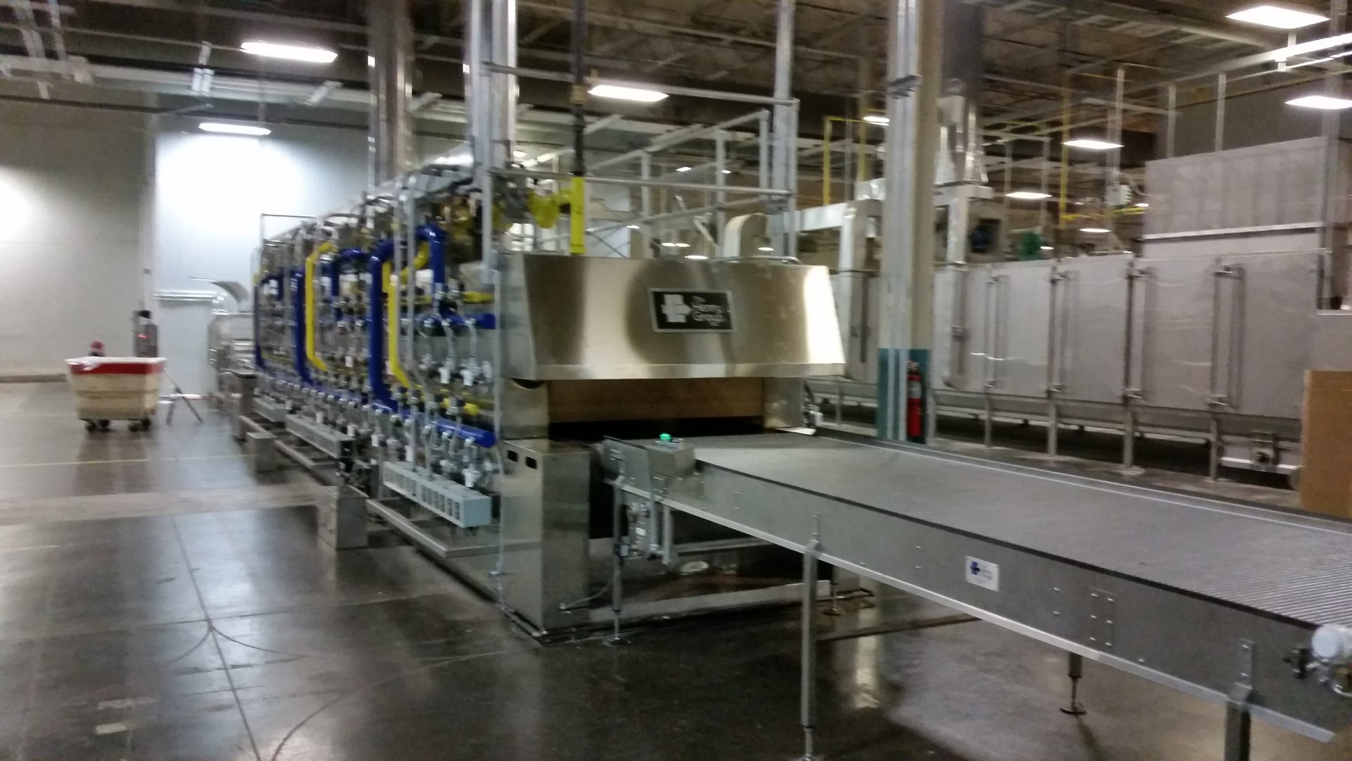 Burner side of the meter-wide hearth-plate tunnel oven, with its discharge conveyor