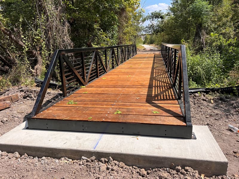 A Roadrunner truss trail bridge set on its concrete abutment